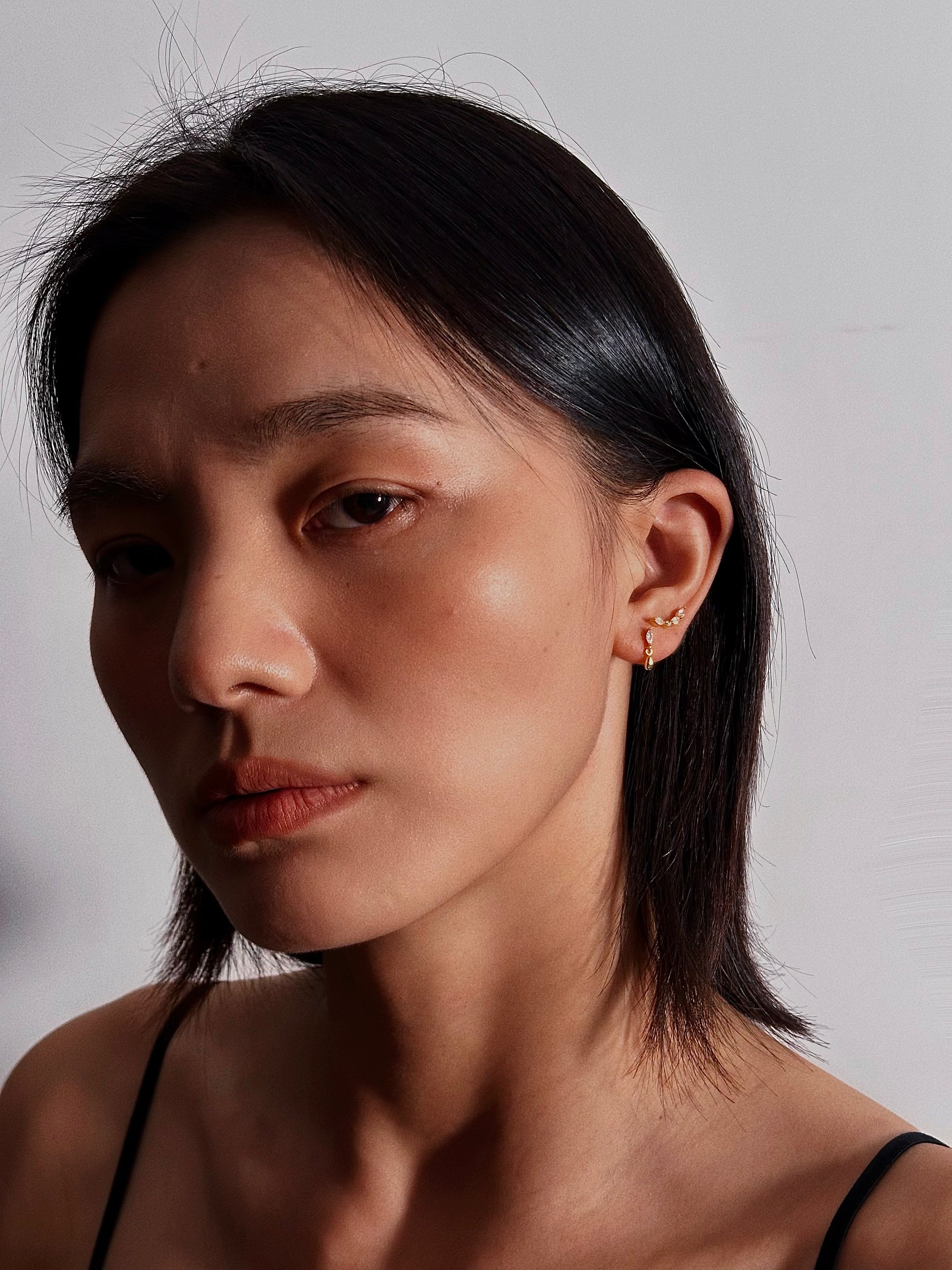 Woman wearing the marquise dangle flatback earring in a casual daytime setting, demonstrating their lightweight elegance and versatile style.