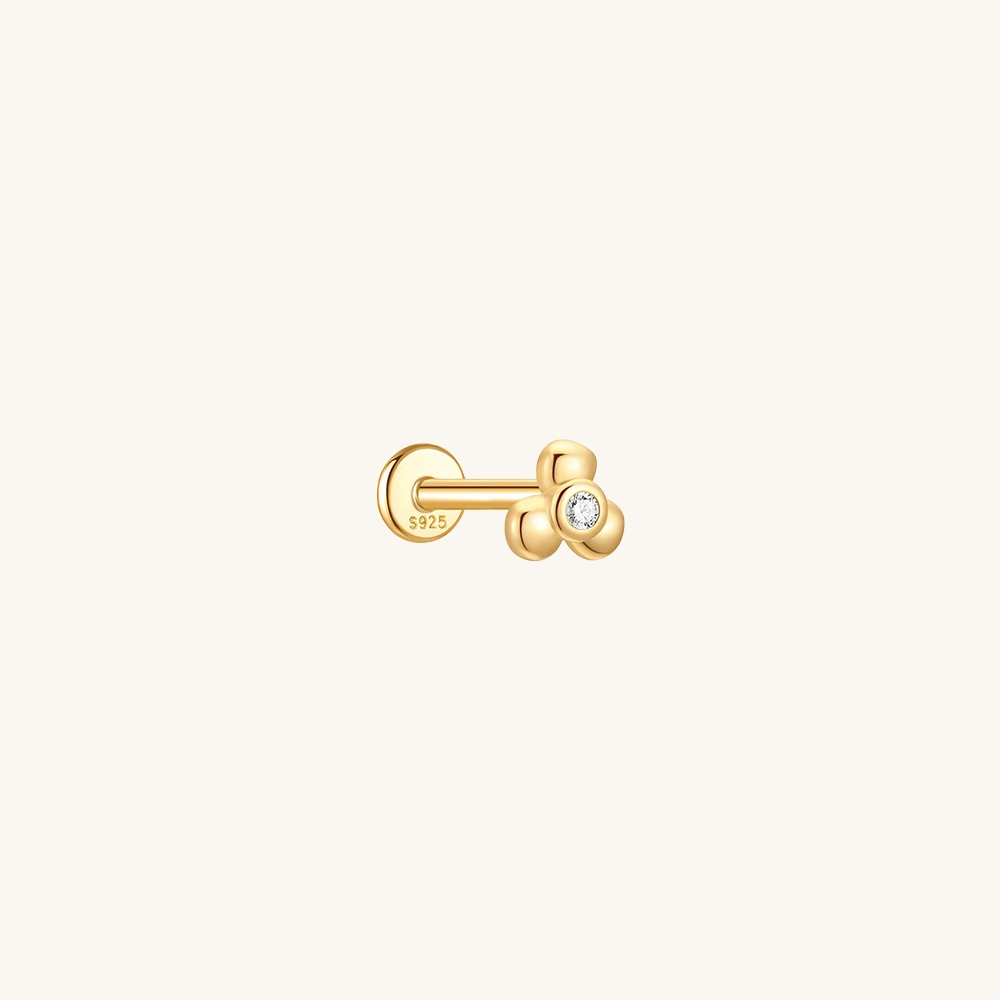 A minimalist close-up of a 3 Petals CZ Flatback Earring in 18k gold-plated sterling silver, showing the delicate floral design and sparkling bezel-set cubic zirconia stone