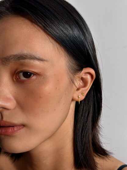 Close-up side profile of a model wearing the 3 Petals floral earring in a lobe piercing, demonstrating its elegant and subtle sparkle in everyday wear