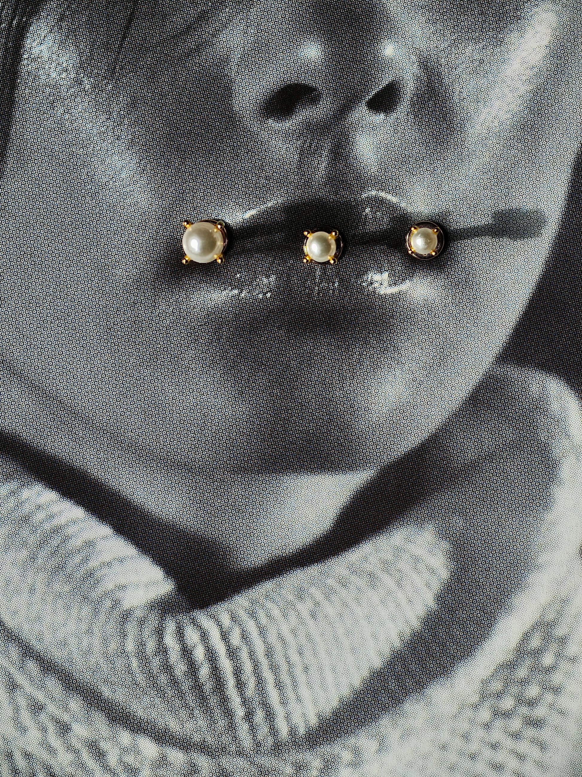 Flat lay of pearl flatback earring in 3 different sizes.