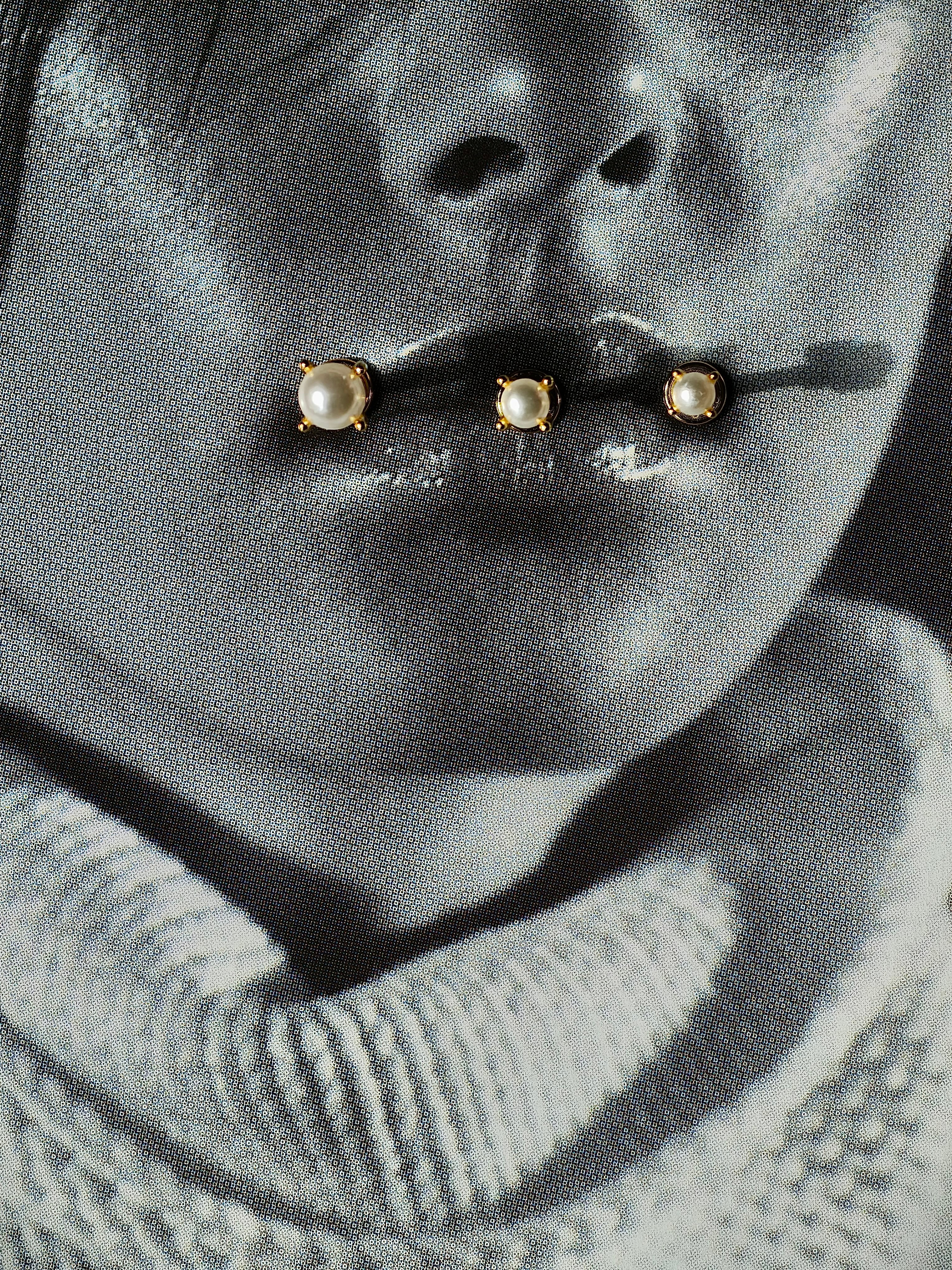 Flat lay of pearl flatback earring in 3 different sizes.