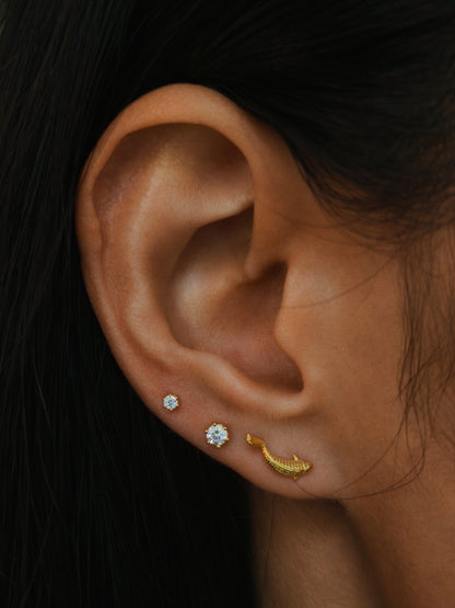 wearing the delicate 2mm & 3mm six-prong CZ flatback stud earrings in gold color on earlobe